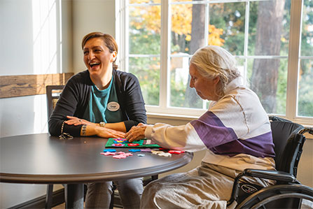 Nurse smiling while playing games with resident