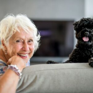 An older woman poses with her dog.