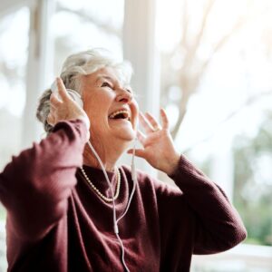 Older woman listens to music on headphones.
