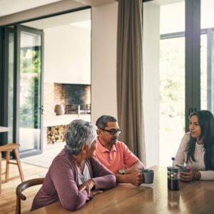 A woman sits down with her parents to talk about senior living.