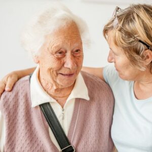 A woman stands with her elderly mother.