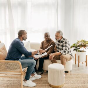 A man sits with his parents during a family meeting.