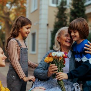 An older woman enjoys time with her grandchildren.