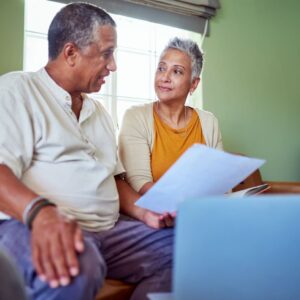 Two older adults sit and discuss their financial plans for the future