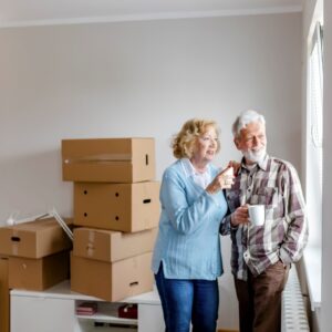 An older couple take a coffee break while packing their home