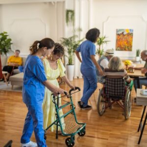 A caregiver shows an older woman through a senior living community.