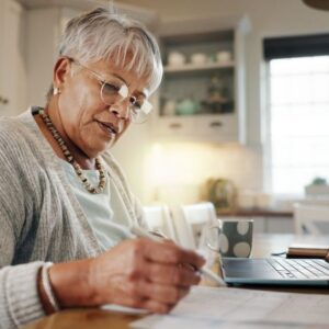 An older woman calculates the cost of senior living.