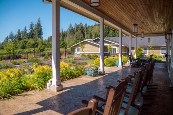 Rocking chairs and game table on the back porch of Fieldstone Memory Care of Silverdale.