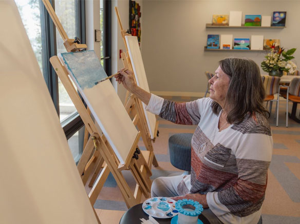 Woman painting scenery on canvas