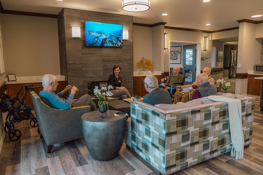 Seniors conversing in a welcoming, modern lounge area.