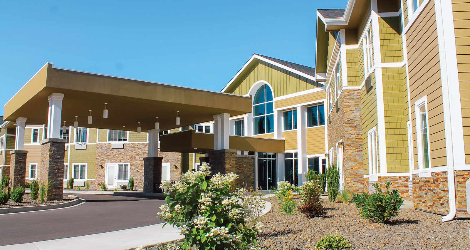 Modern building with a covered entrance and landscaped surroundings.