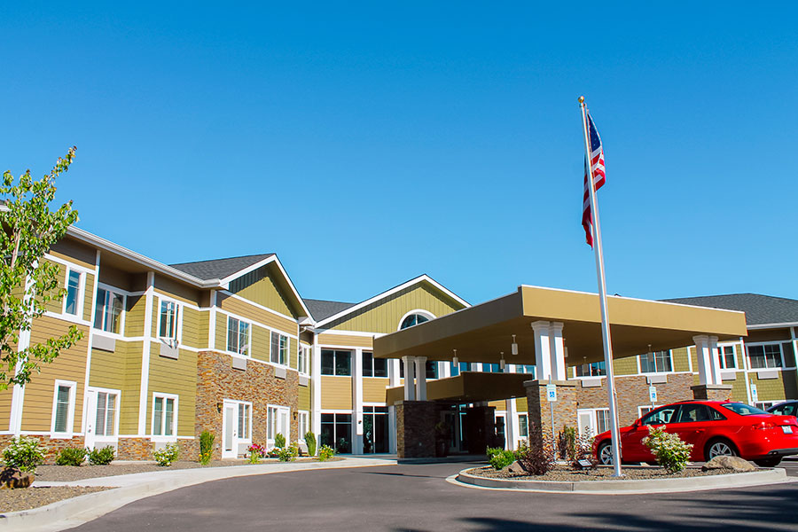 Modern building entrance with flag and clear blue sky.