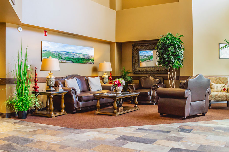 Cozy lounge area with plants, furniture, and artwork.