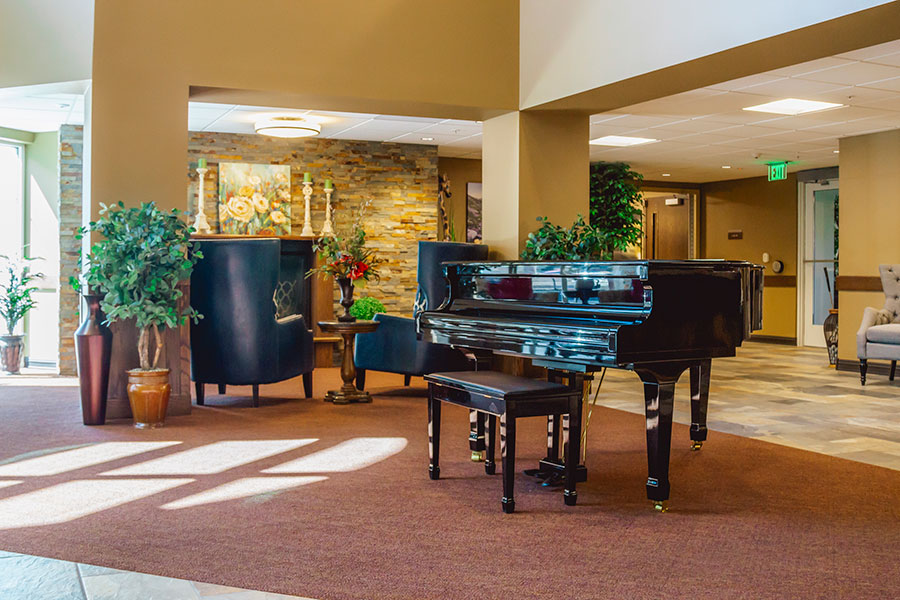 Elegant lobby with a grand piano and decorative plants.