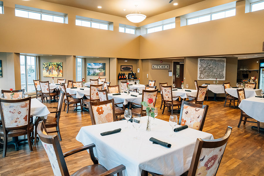 Elegant restaurant interior with tables, chairs, and artwork.