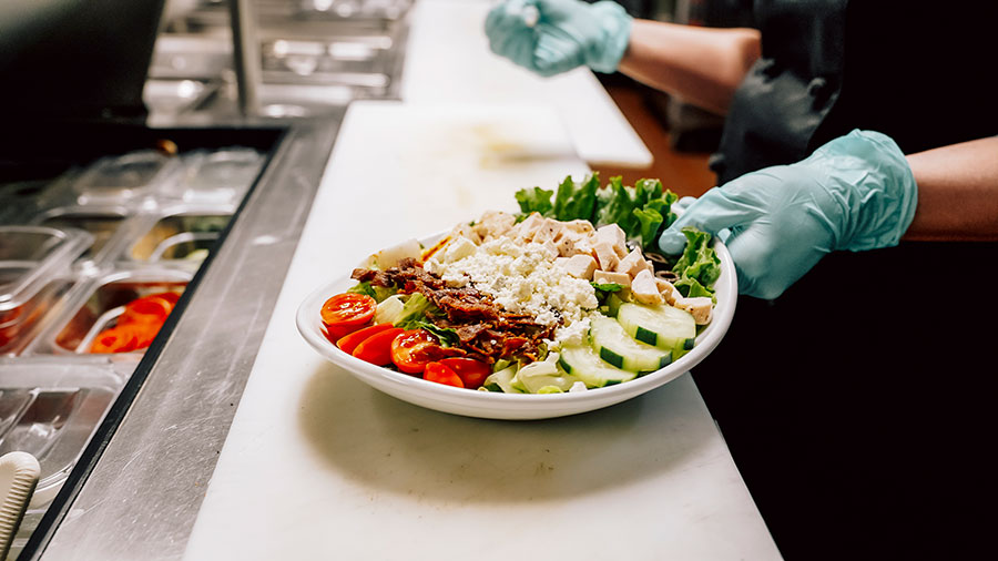 Fresh salad with vegetables, chicken, and cheese.