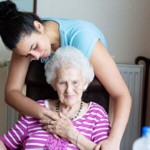 A woman embraces an older loved one.